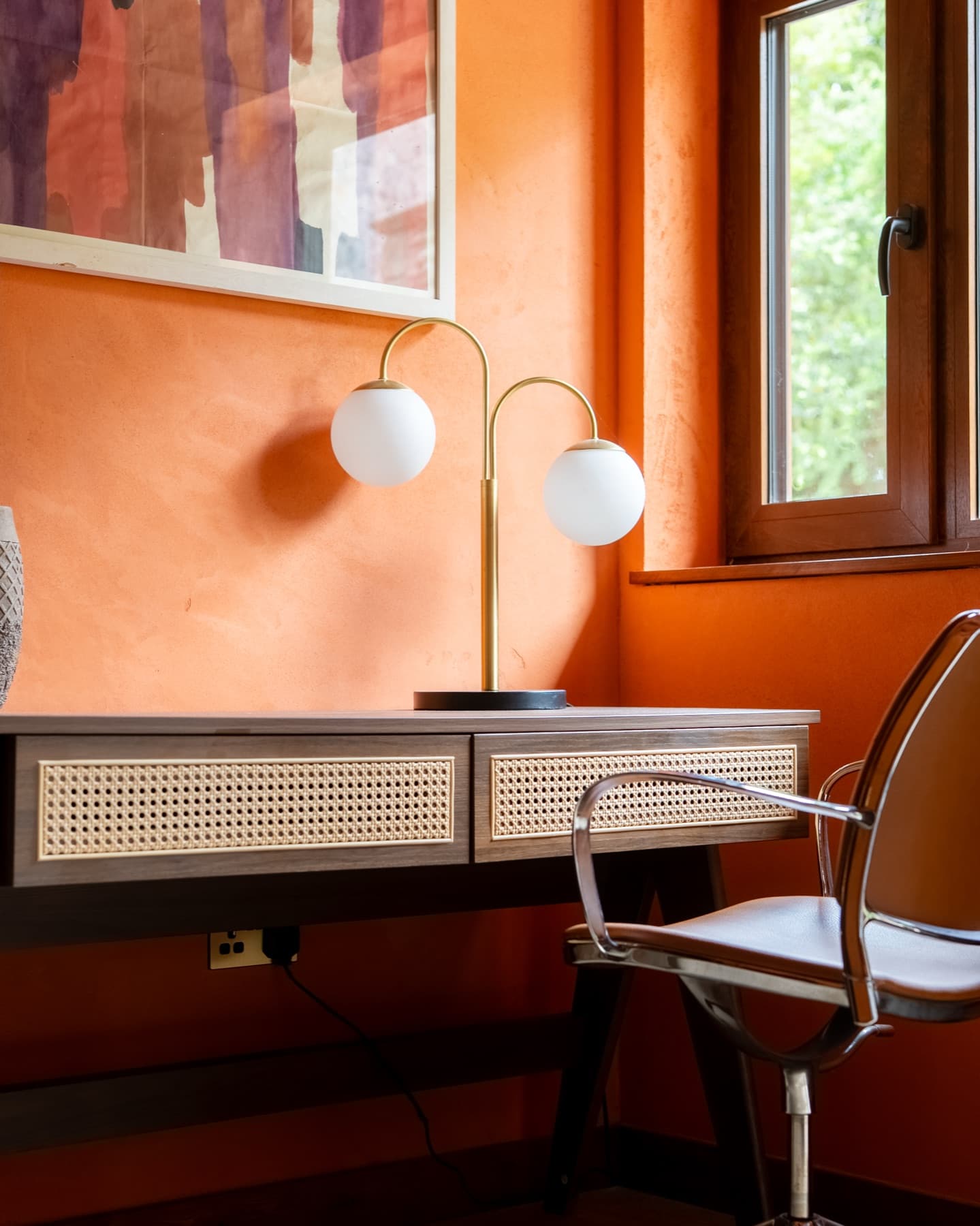 Cane-fronted desk and brass globe lamp