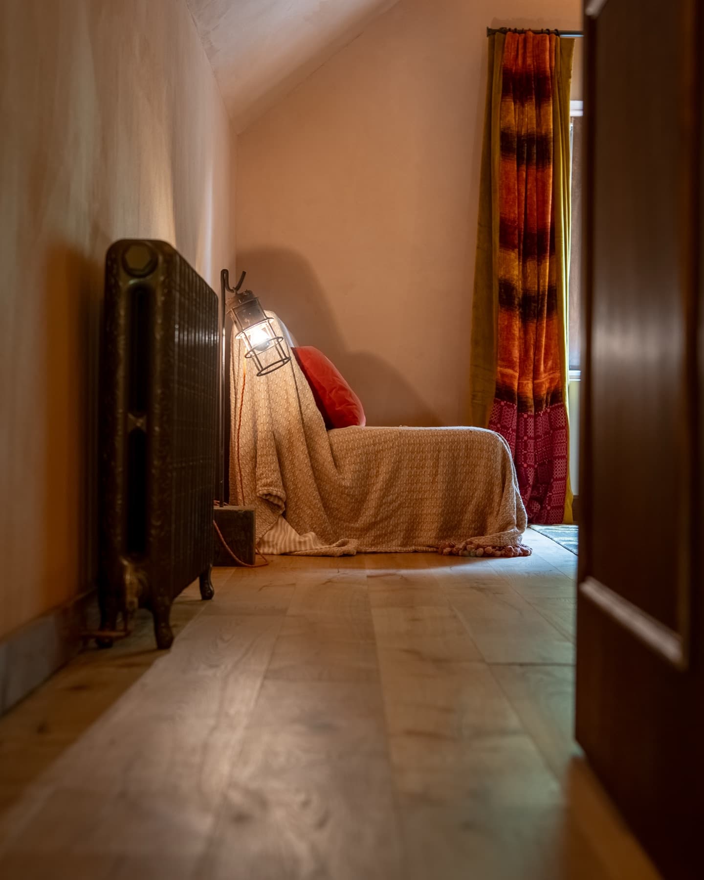 Lantern lamp and cast-iron radiator beside the sofa bed