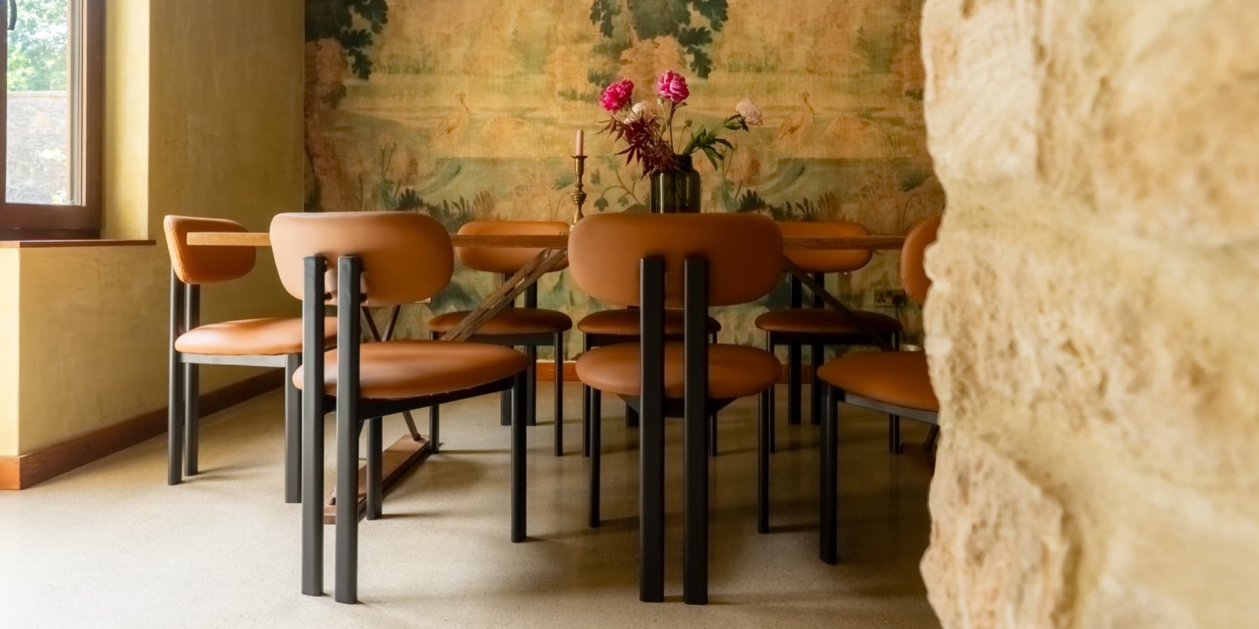 Tapestry dining room, antique wall hanging and tan leather chairs
