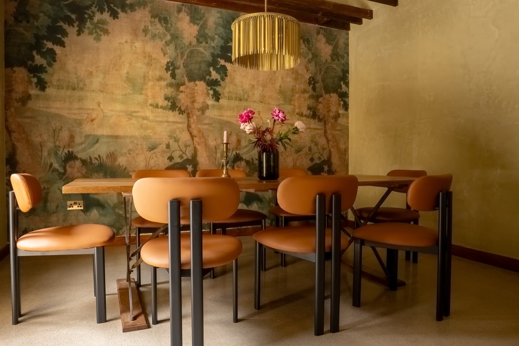 The painted tapestry wall behind the dining table