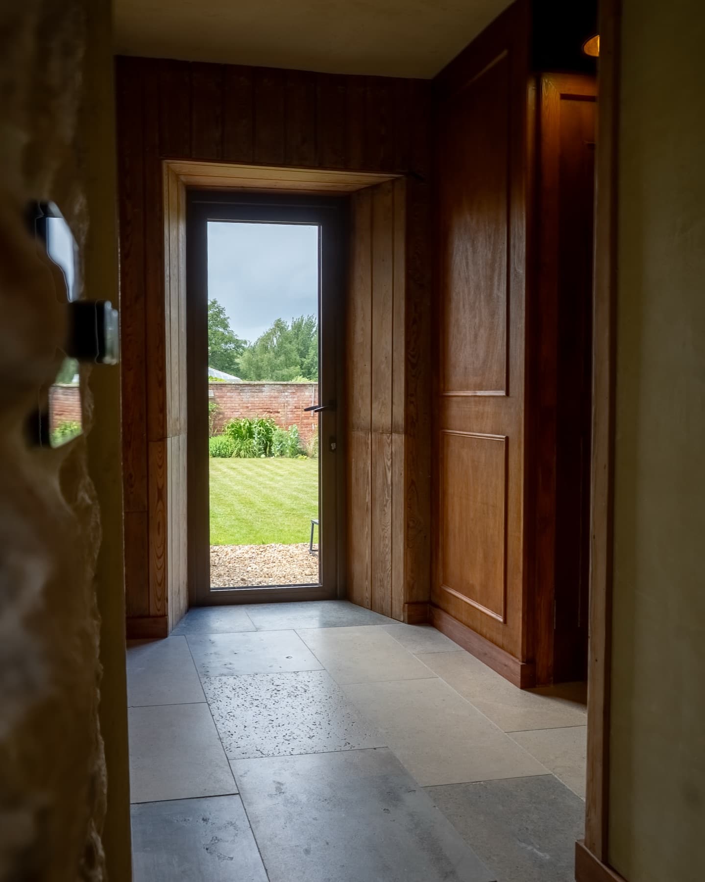 Oak-panelled entrance hall with the garden door standing open