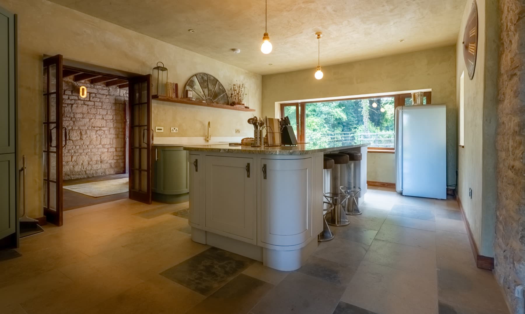 Kitchen island, bar stools and the window onto the trees