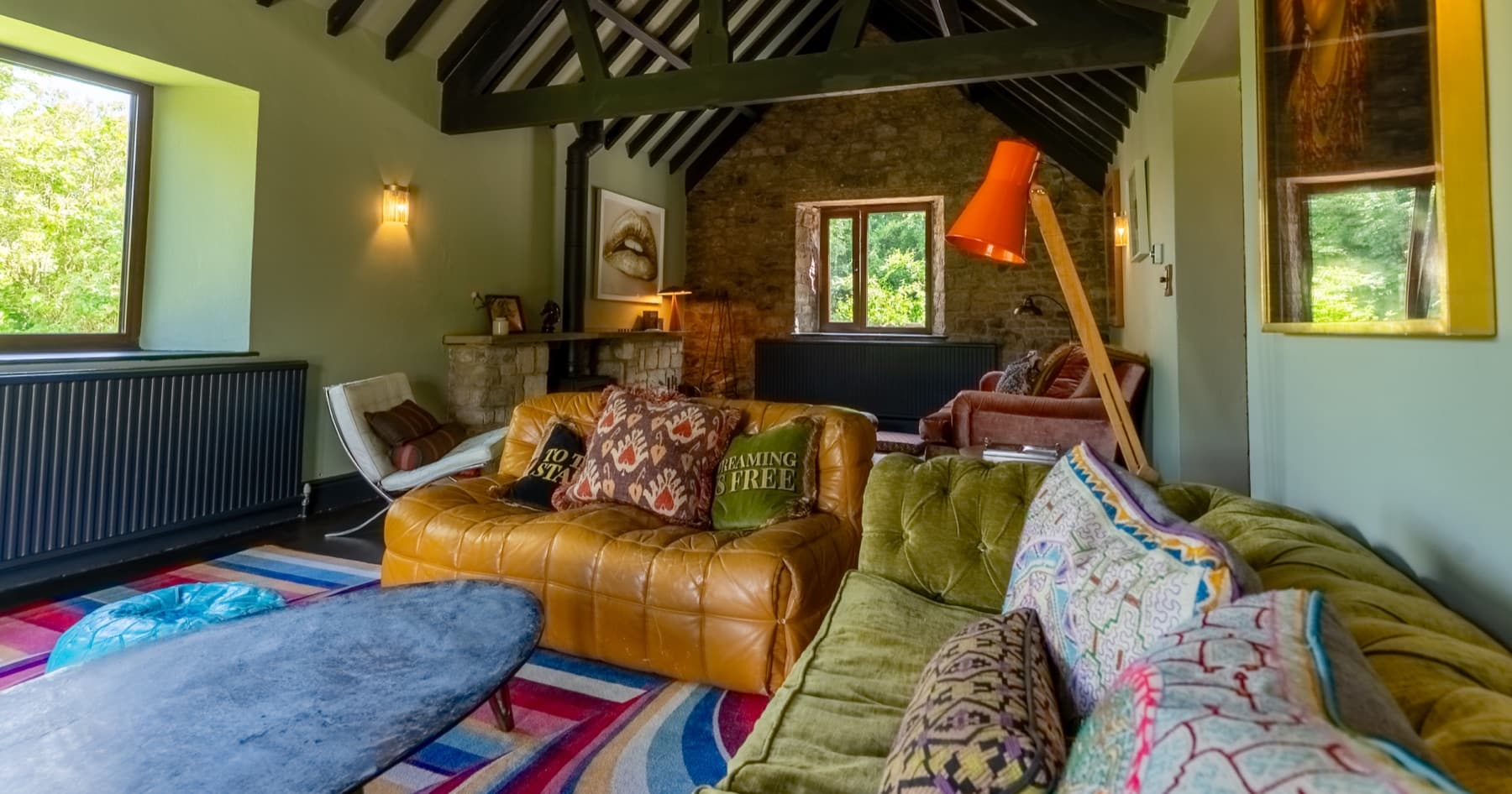 Sitting room with roof trusses, leather and velvet sofas